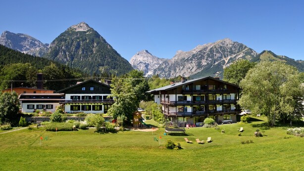 A hotel with a two-story structure, a playground, and a well-maintained lawn.