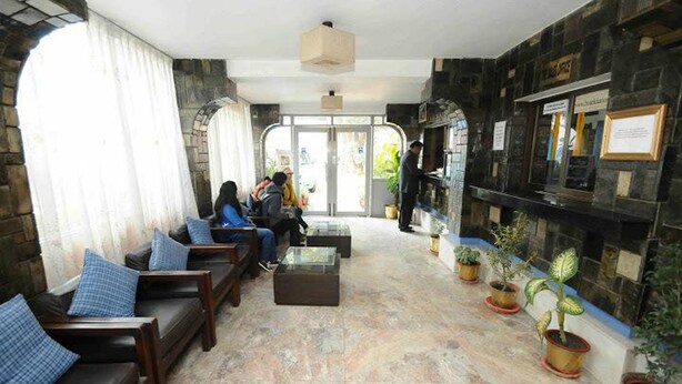 A lobby with seating, a reception desk, and potted plants. - Hotel Clarion (Lalitpur)