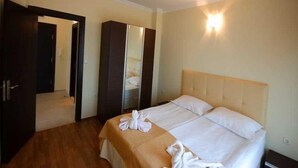 A hotel room with a bed, a wardrobe, and a mirror. - St George Palace (ST VLAS)