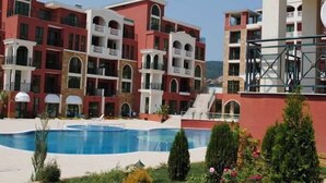 A multi-story hotel with balconies, a swimming pool, and landscaped gardens. - St George Palace (ST VLAS)