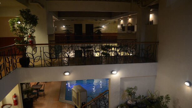 A multi-level indoor space with a dining area, a staircase, and a water feature. - DM Residente Inns and Villas (Angeles City)