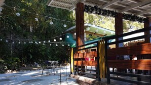 An outdoor seating area with string lights, wooden tables, and chairs. - Mountain Lodge (Baguio)