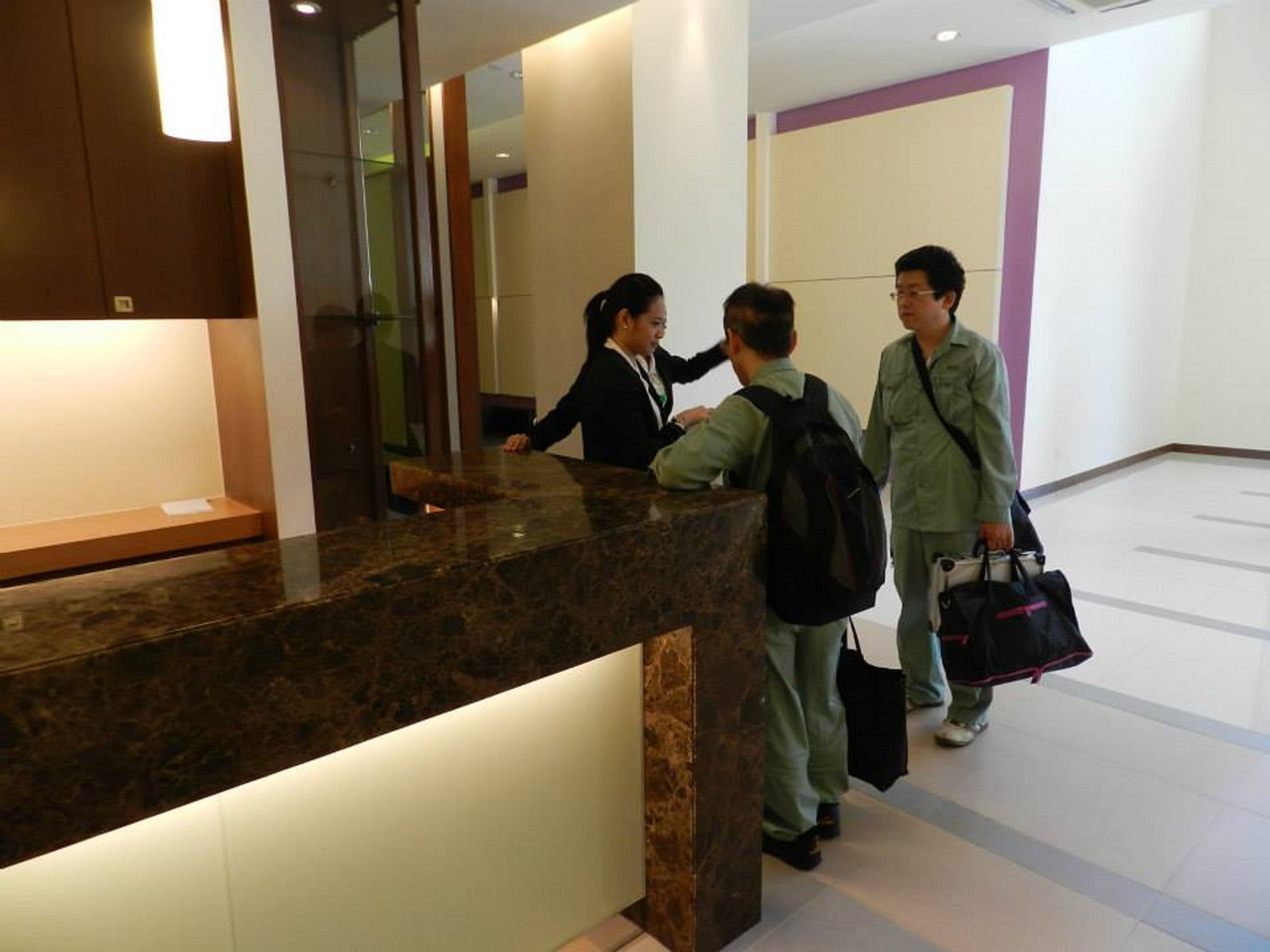 A reception desk with a marble counter and a glass partition.