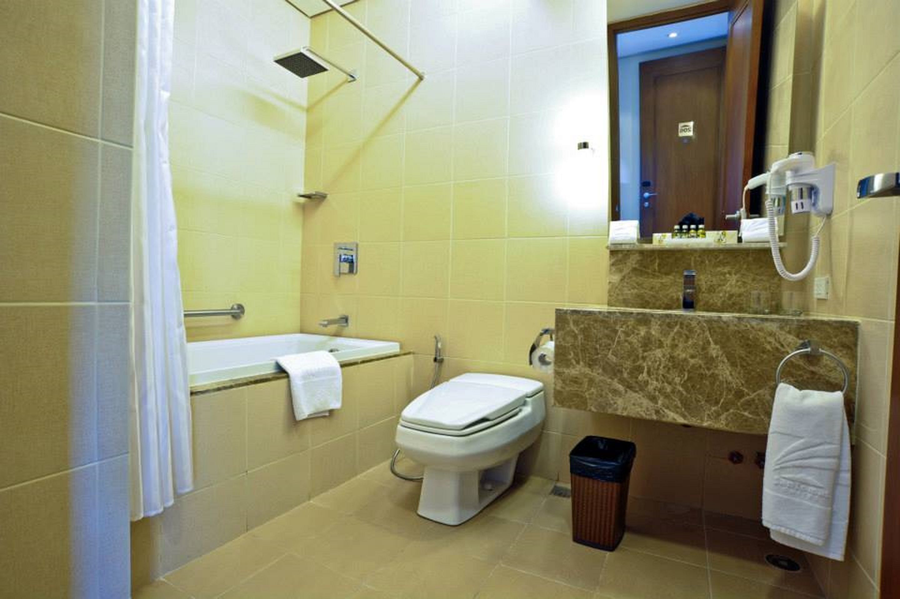 A bathroom with a toilet, sink, and shower.