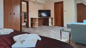 Une chambre d’hôtel avec un lit, une télévision, un bureau et une chaise.