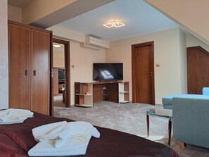 Une chambre d’hôtel avec un lit, une télévision, un bureau et une chaise.