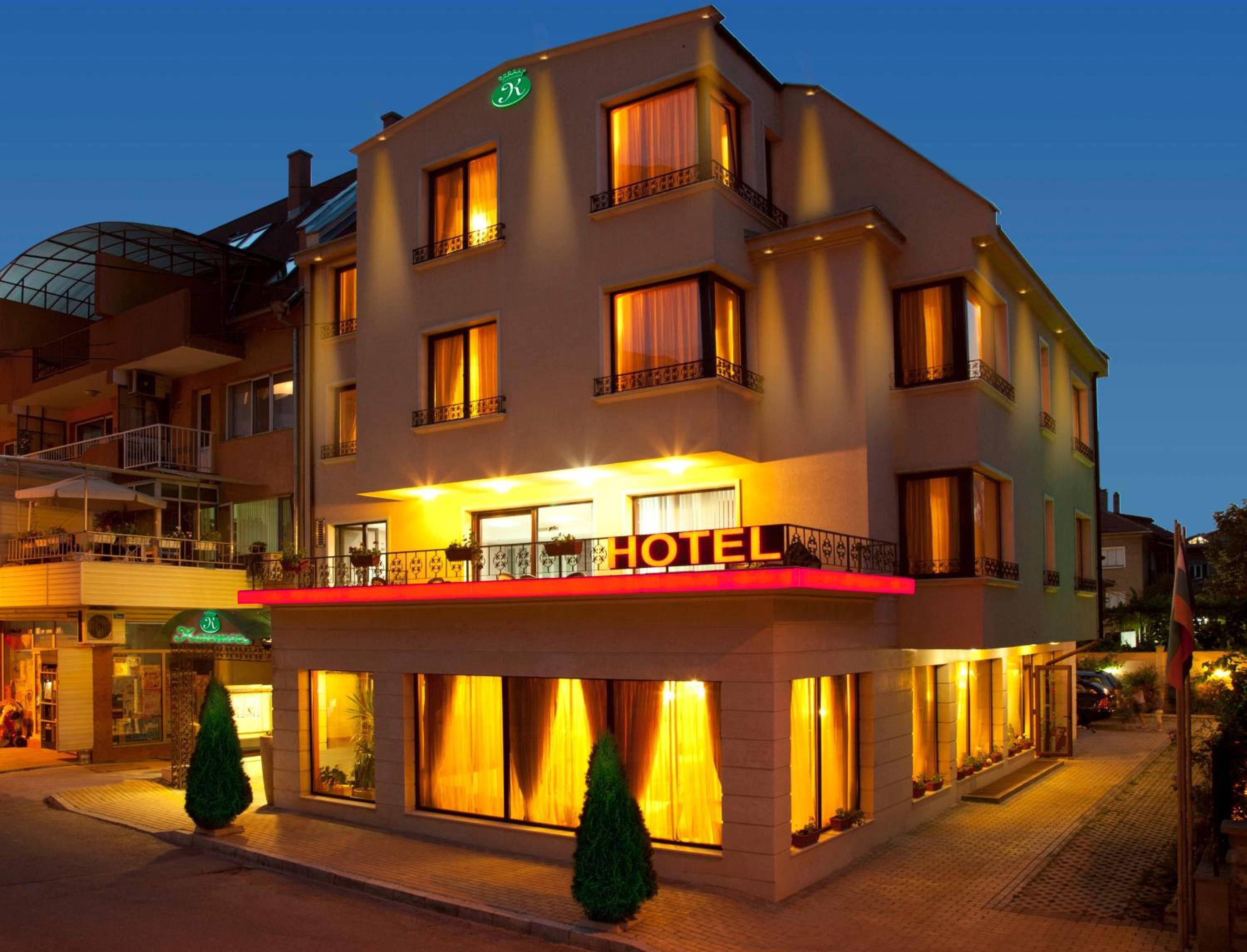 A multi-story hotel with a prominent 'HOTEL' sign, balconies with railings, and large windows.