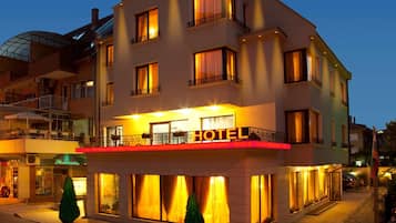 A multi-story hotel with a prominent 'HOTEL' sign, balconies with railings, and large windows.