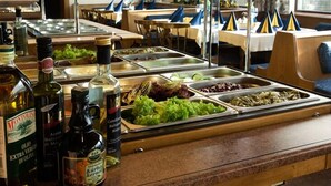 Uma área de buffet com diversos alimentos e acompanhamentos.