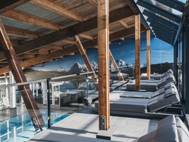 Una piscina techada, sillones reclinables de piscina