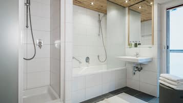 A modern bathroom with white tiles, a wooden ceiling, a bathtub, a shower, and a sink with a mirror above it.