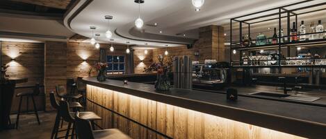 A bar area with wooden accents, bar stools, and a well-lit interior.
