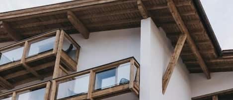 Un edificio de varios pisos con fachada blanca y balcones de madera.
