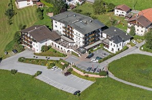 Un hôtel à plusieurs étages doté d’une cour intérieure, d’un espace extérieur aménagé avec des sièges et d’un parking.