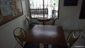 A small dining area with a wooden table and four chairs. - Malate Pensionne (Manila)