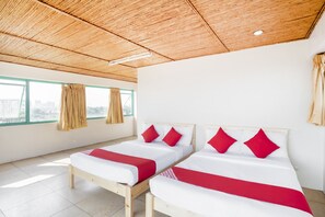 A hotel room with two beds, wooden headboards, and a view of the city through large windows. - Manila Airport (Manila)