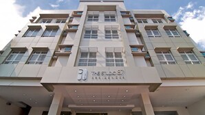 A multi-story hotel with a modern architectural design, featuring a prominent entrance with a sign reading "The Studio 87 Residences". - The Studio 87 Residences (Quezon City)