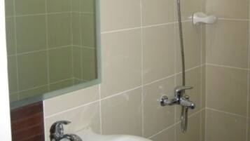 A bathroom with a sink, mirror, and shower.