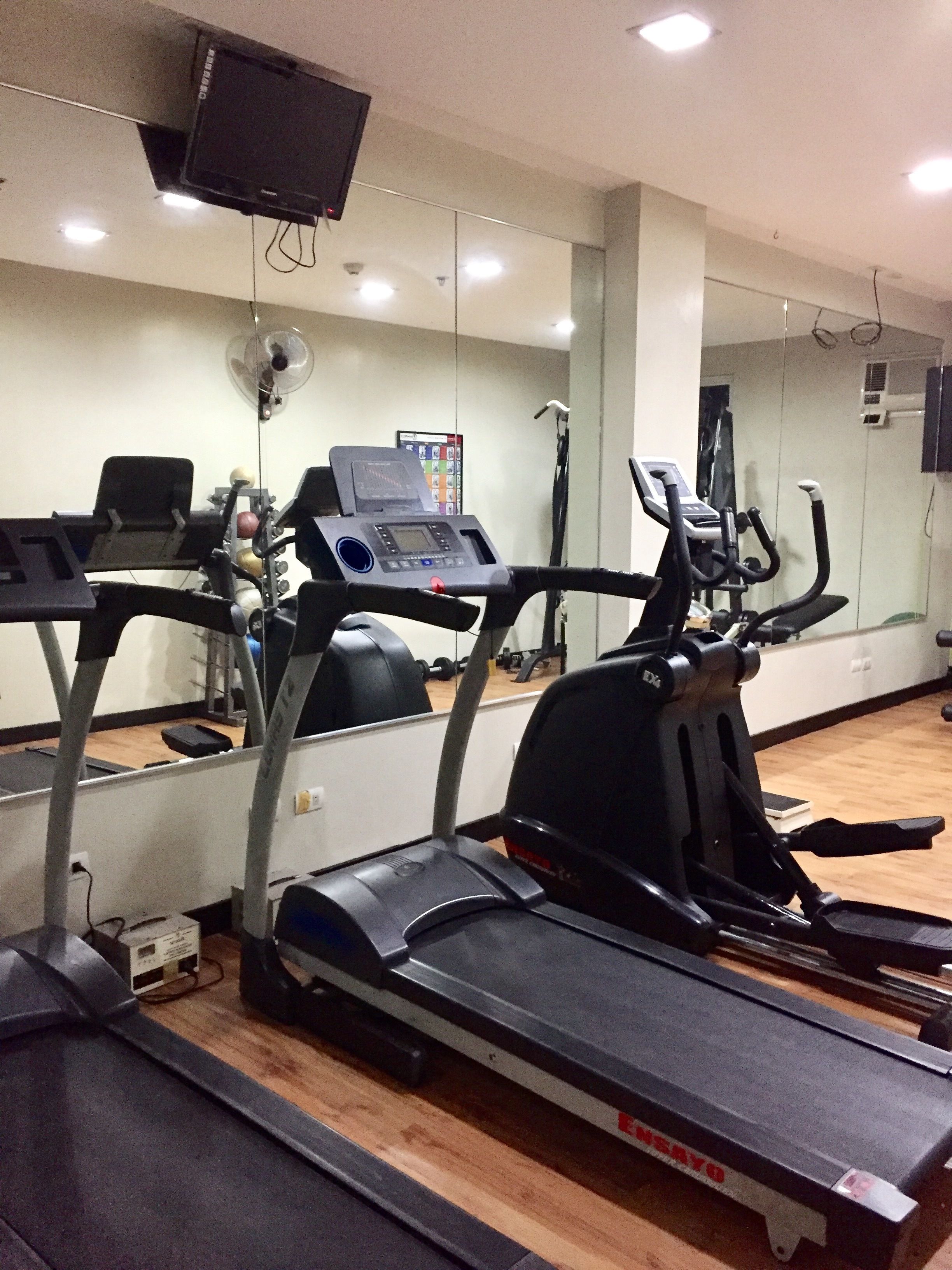 Ett gym med löpband, crosstrainer och vikter.