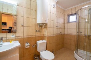 A bathroom with a toilet, sink, and shower.