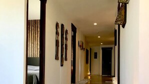 A hallway with a stone pathway, wooden doors, and wall-mounted decorations. - Segara Villas (Olongapo)