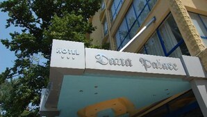 Letrero de hotel con el nombre 'Dazpa Palace' y una vista parcial de la fachada del edificio.