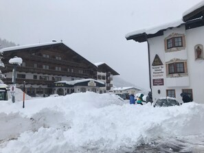 A snow-covered building with a sign for a restaurant and a bar. - Hotel Thaler (Thiersee)