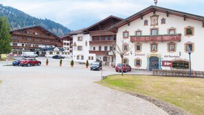 A traditional Alpine-style building with multiple balconies and a sign indicating a restaurant. - Hotel Thaler (Thiersee)