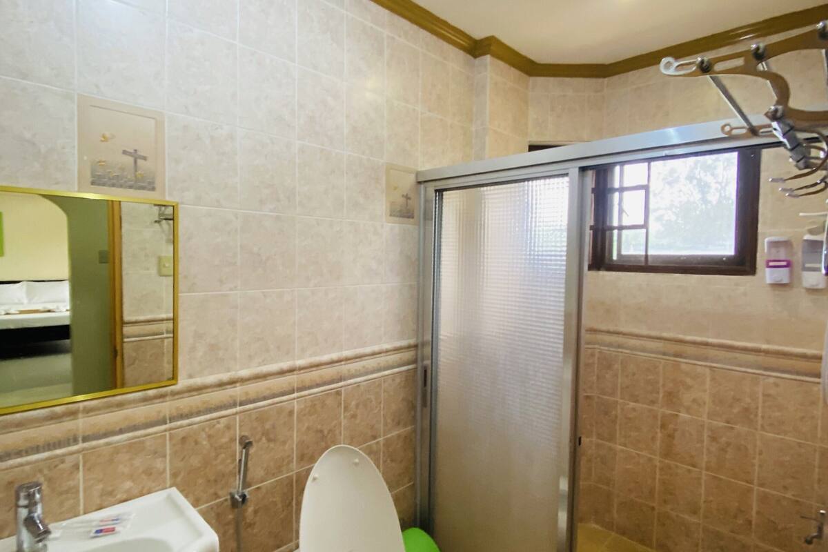 A bathroom with a toilet, sink, and shower area.