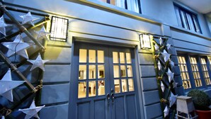 A building facade with a large central door, multiple windows, and decorative star-shaped lights. - Almont City Hotel (Butuan)
