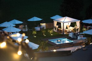 A pool area with umbrellas, a gazebo, and outdoor seating.