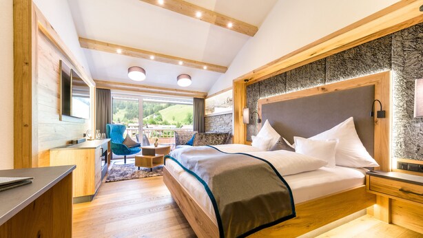 Un dormitorio moderno con una cama grande, cabecera de madera y un espacio de escritorio.