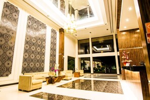A spacious lobby with patterned wallpaper, a chandelier, and a reception desk. - Ariana Hotel (Dipolog)