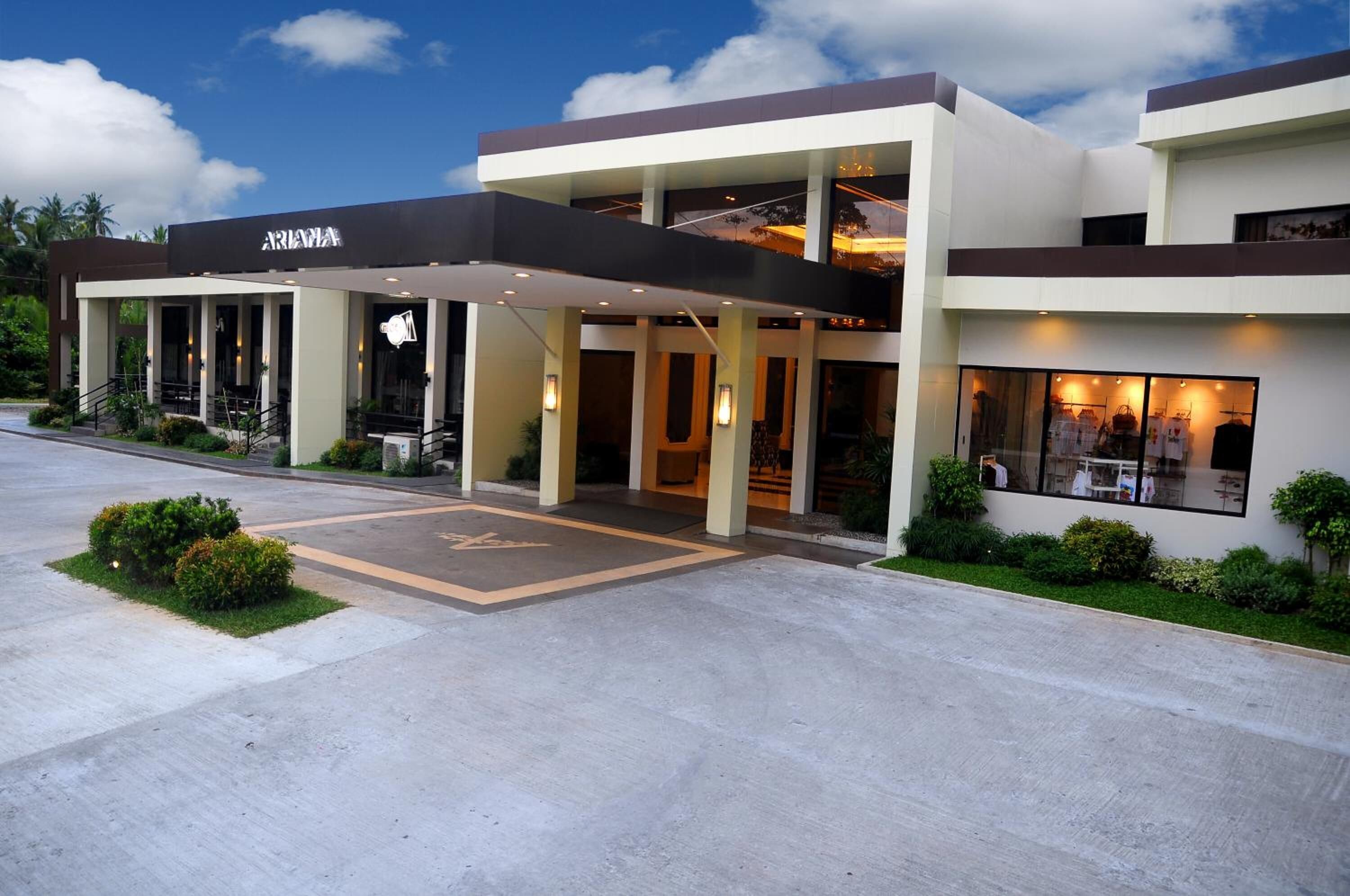 Um hotel moderno com entrada coberta, área de estar ao ar livre e restaurante à vista.