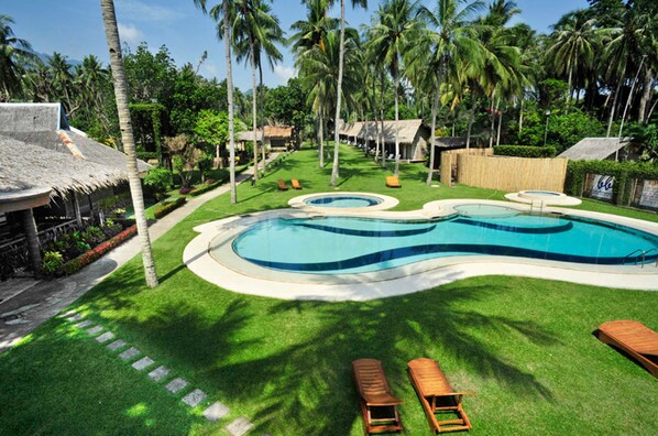 Una piscina al aire libre, sillones reclinables de piscina