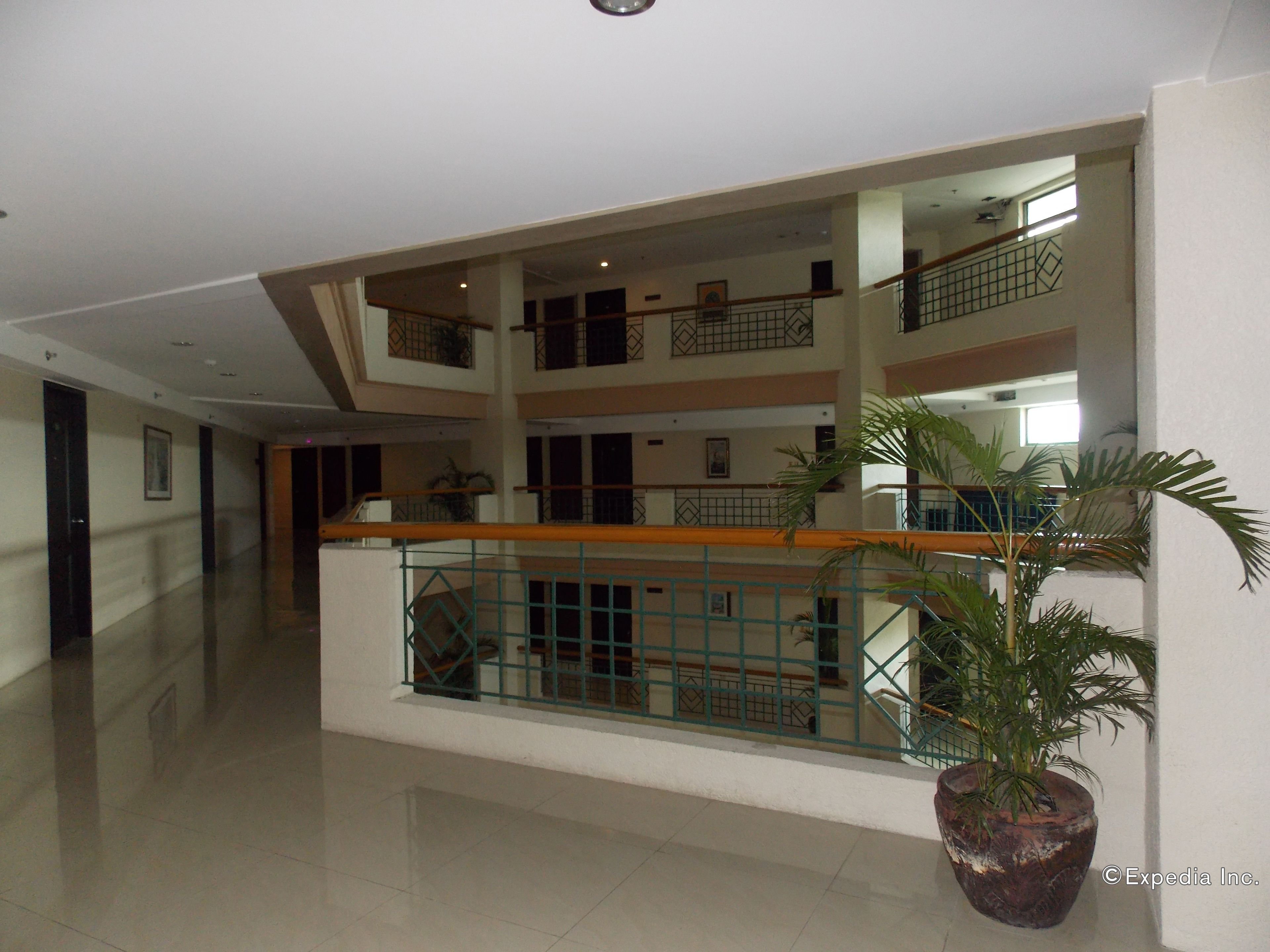 A multi-level interior with a central atrium, glass railings, and a potted plant.