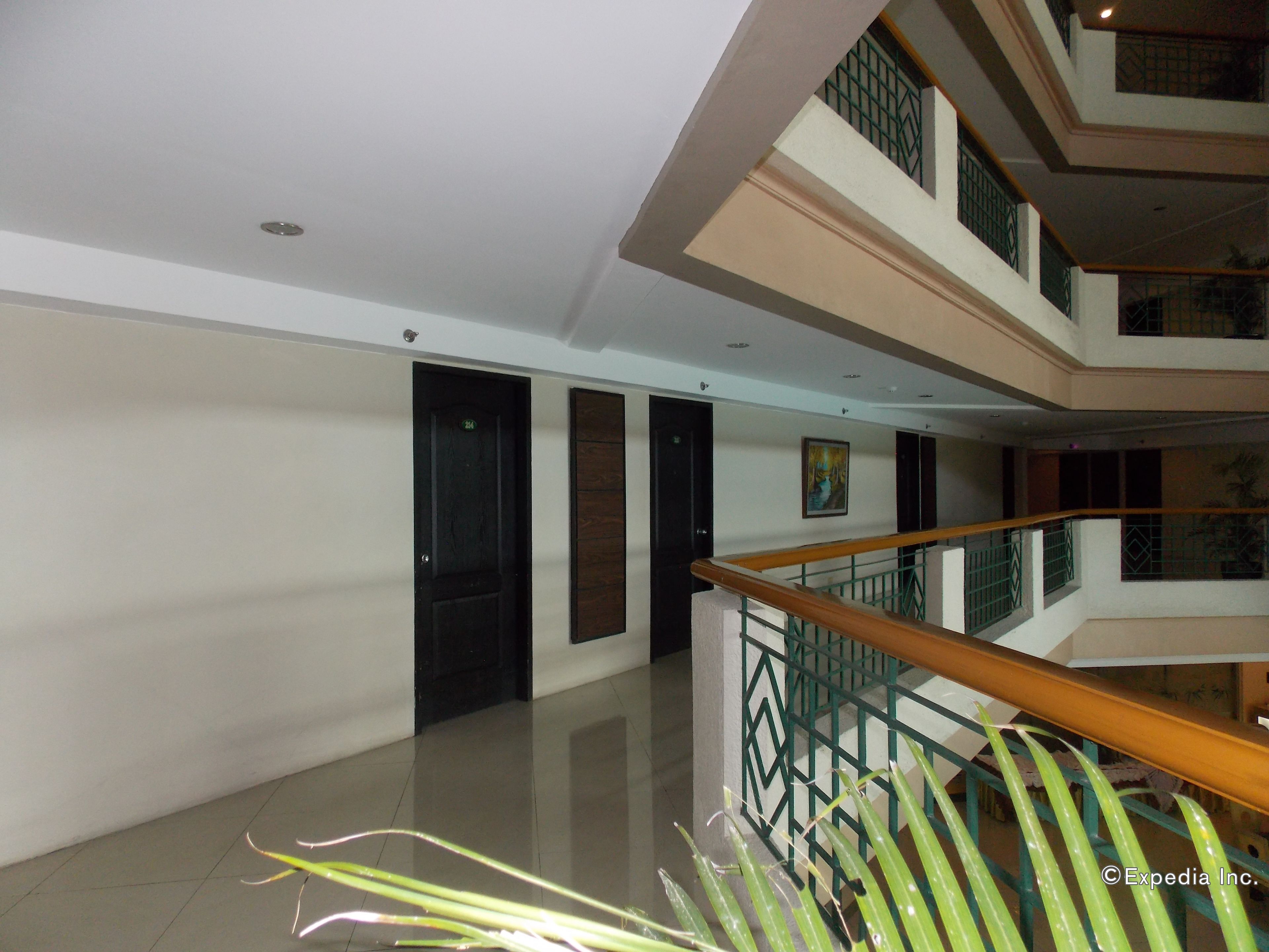 A multi-level interior with a wooden staircase, tiled floors, and a painting on the wall.