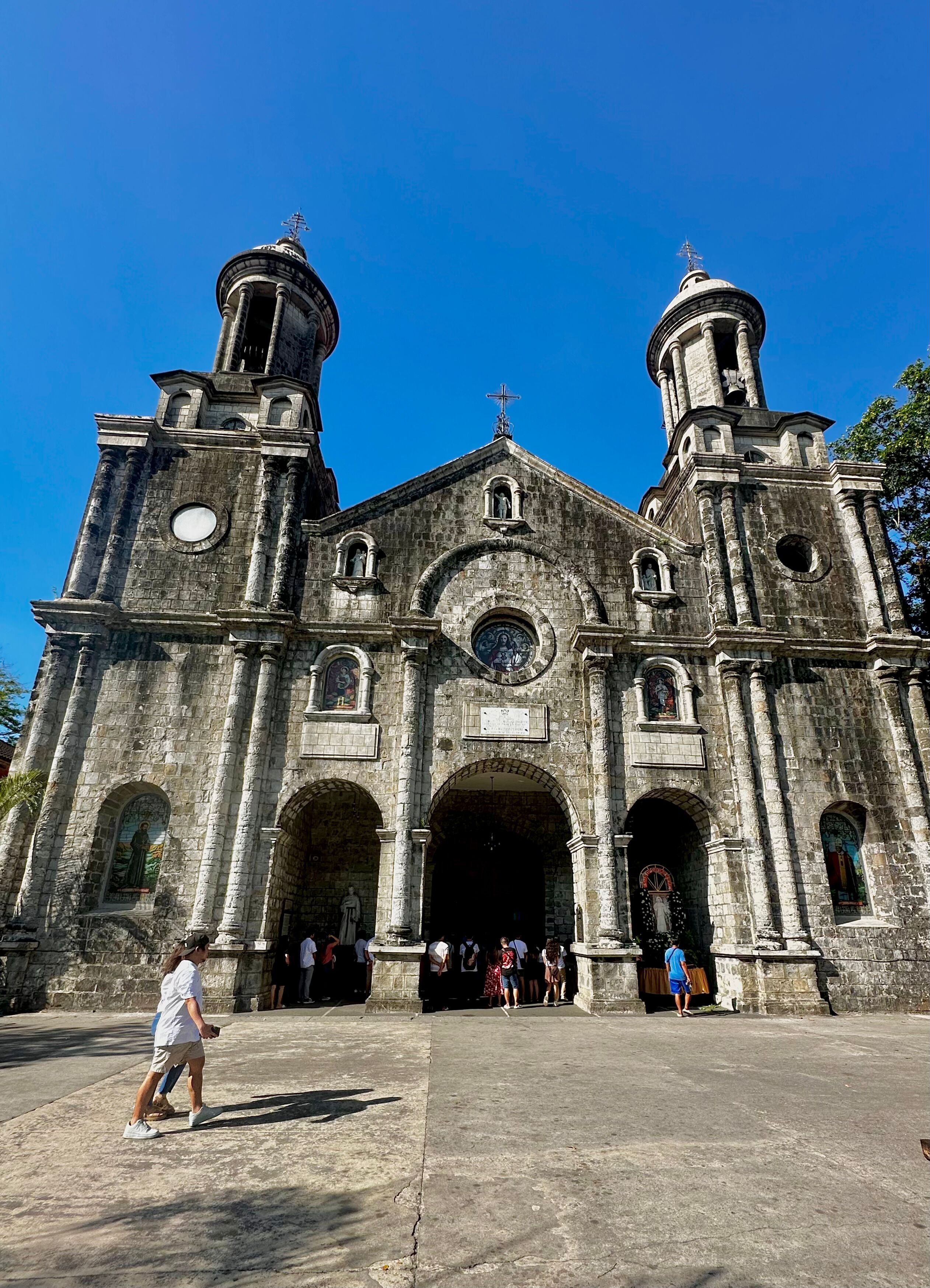 A historic church with two bell towers, large arched doorways, and a central dome.