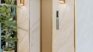 Un ascensor con diseño moderno, con acabados en madera clara y una pantalla digital.