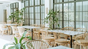 Restaurante con terraza, sillas de mimbre y amplios ventanales.