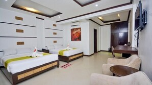 A hotel room with two beds, a TV, a desk, and a chair. - Bamboo Beach Resort and Restaurant (Balabag)