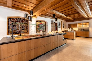 A modern kitchen with wooden cabinets, a central island, and pendant lighting.