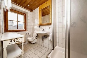 A bathroom with a toilet, sink, and shower.