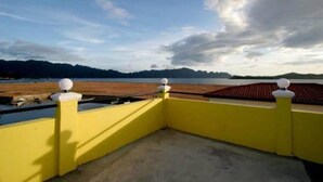A yellow balcony with a view of a lake and distant mountains. - Luis Bay Travellers Lodge Coron (Coron)