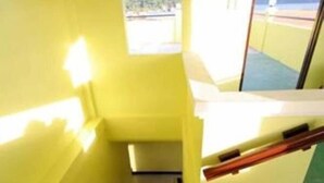 A staircase with a view of a mountainous landscape through a window. - Luis Bay Travellers Lodge Coron (Coron)