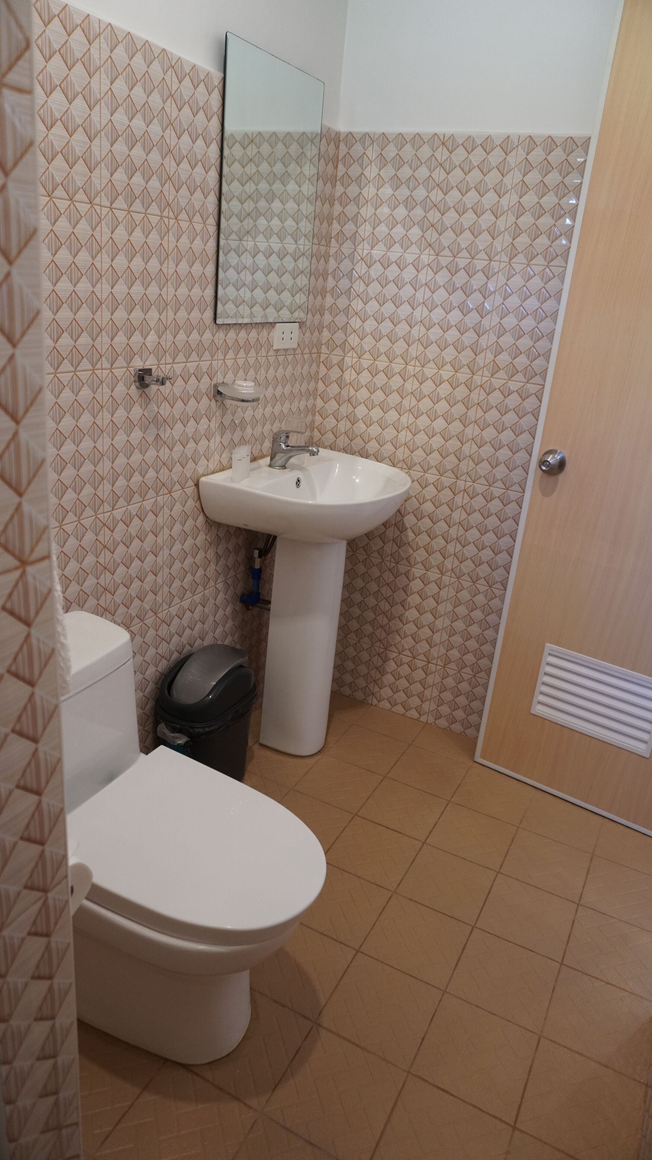 Une salle de bain avec des toilettes, un lavabo et un miroir.