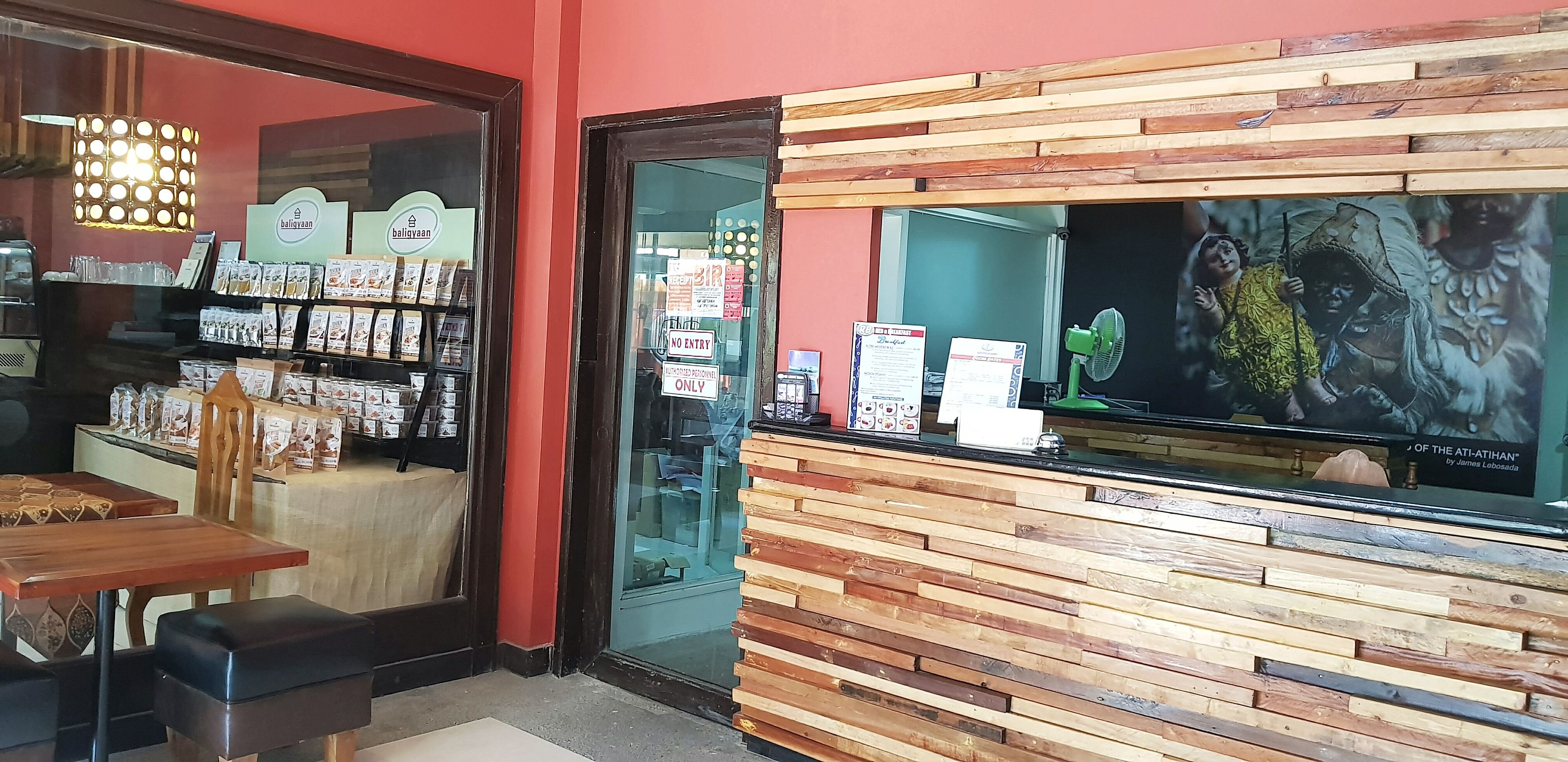 A restaurant interior with wooden paneling, a glass display case, and a menu board.