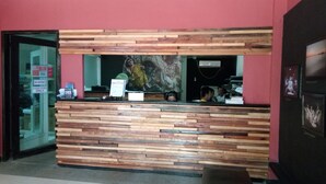Una recepción con diseño de panel de madera, puerta de entrada de vidrio y un cartel en la pared.