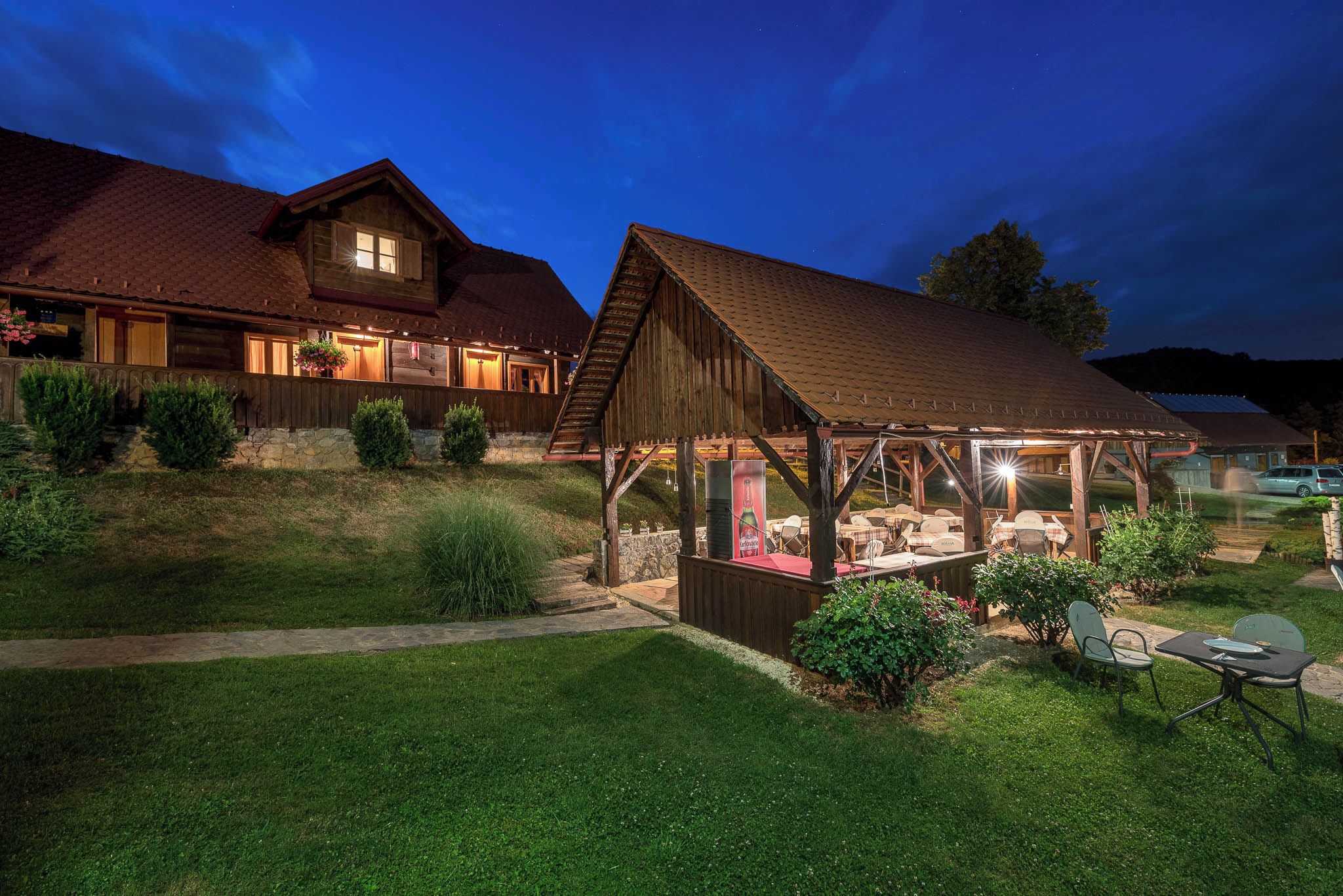 A rustic wooden house with a covered patio and a stone pathway.