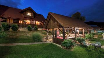 A rustic wooden house with a covered patio and a stone pathway.
